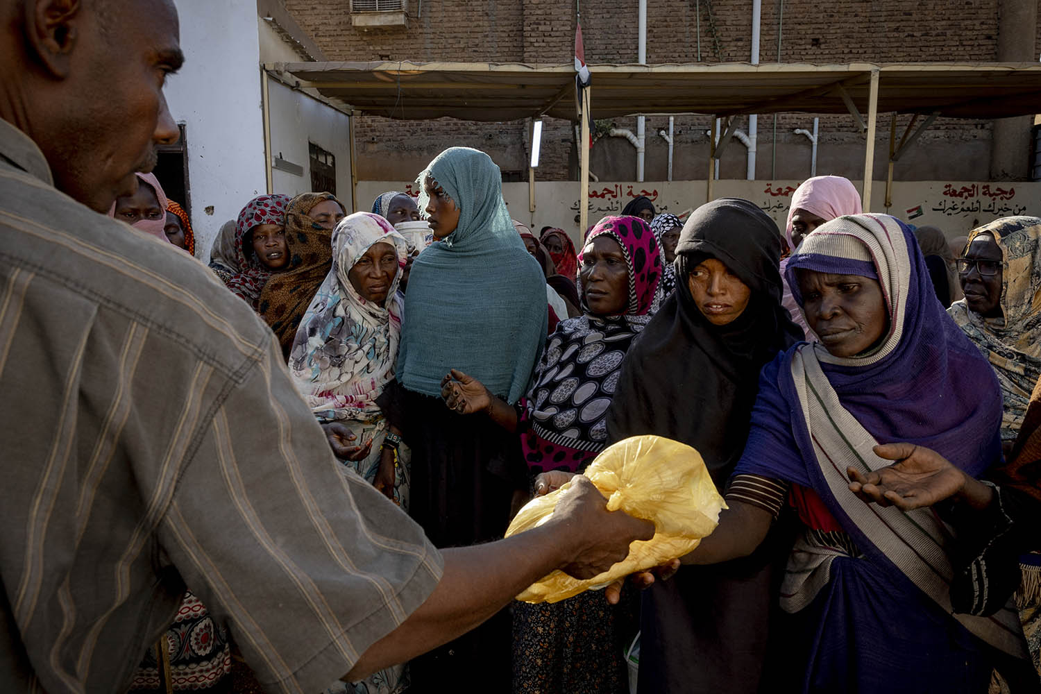 Women line up to receive bread at a soup kitchen in Omdurman, on the western side of Khartoum