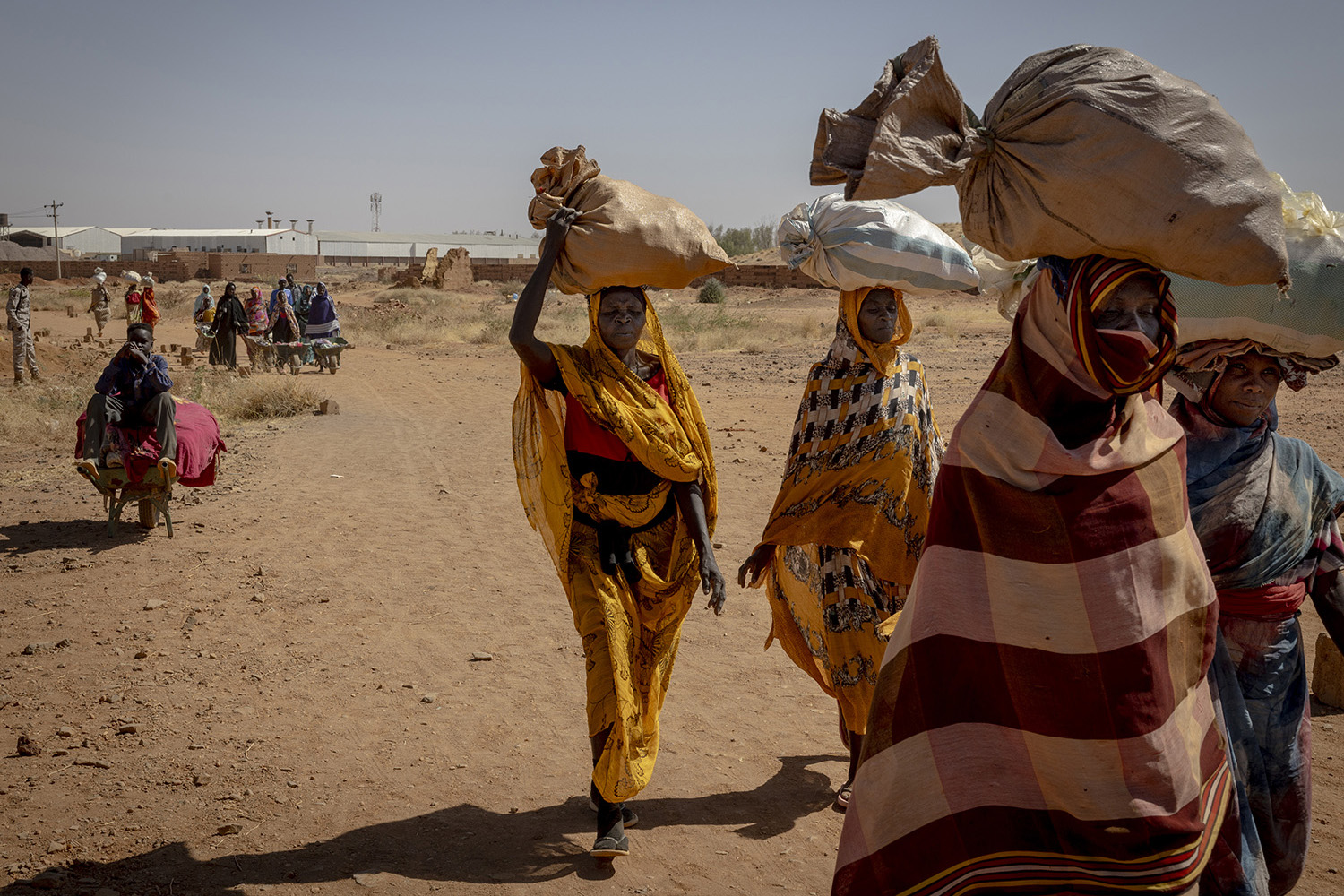 Civilians return to RSF-controlled territory on the western edge of Omdurman after crossing into government-controlled areas to buy food and produce at a cheaper price