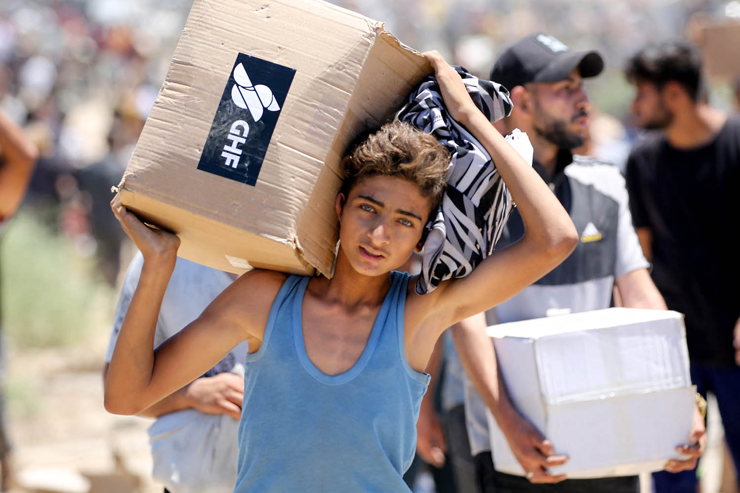 A boy carries aid from the US-backed private Gaza Humanitarian Foundation (GHF). AFP/Getty