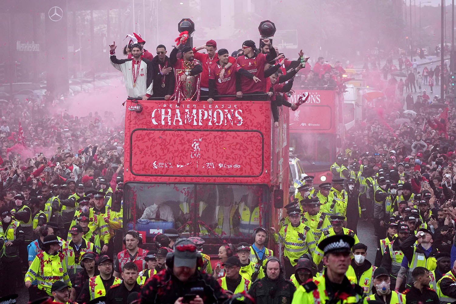 Liverpool fans flock around the team bus as the squad shows off the Premier League trophy.
