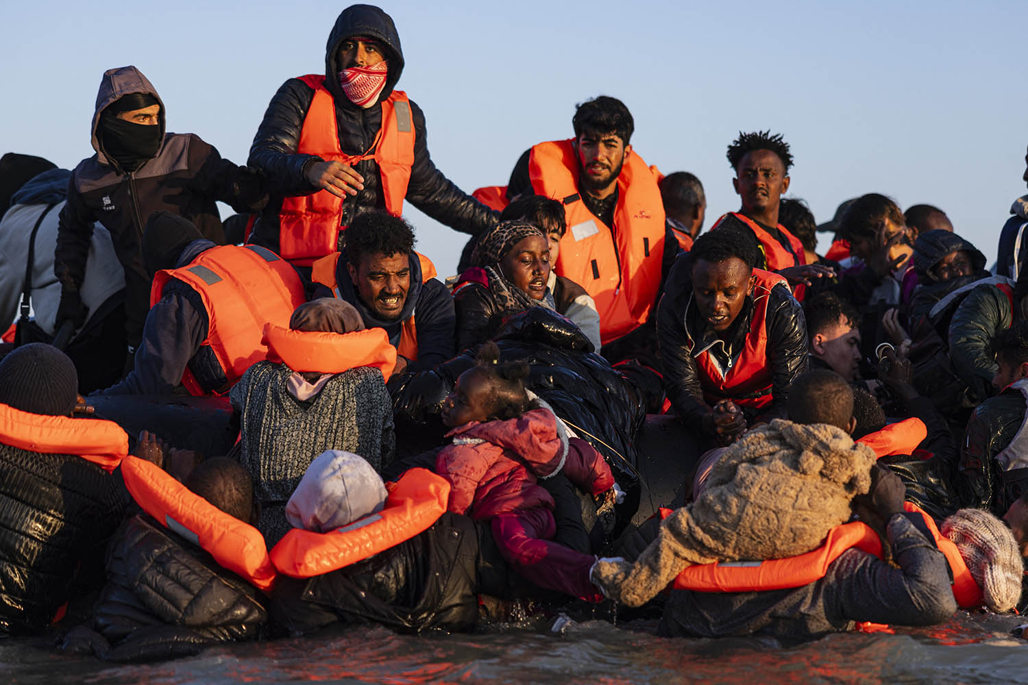 Migrants try to board a smuggler's boat in an attempt to cross the English Channel off the beach of Gravelines