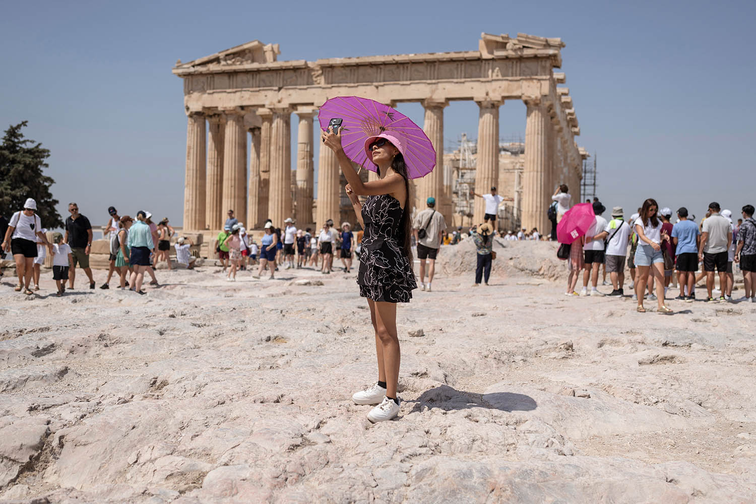 Tourists visit the Parthenon temple atop the Acropolis hill in Athens.
