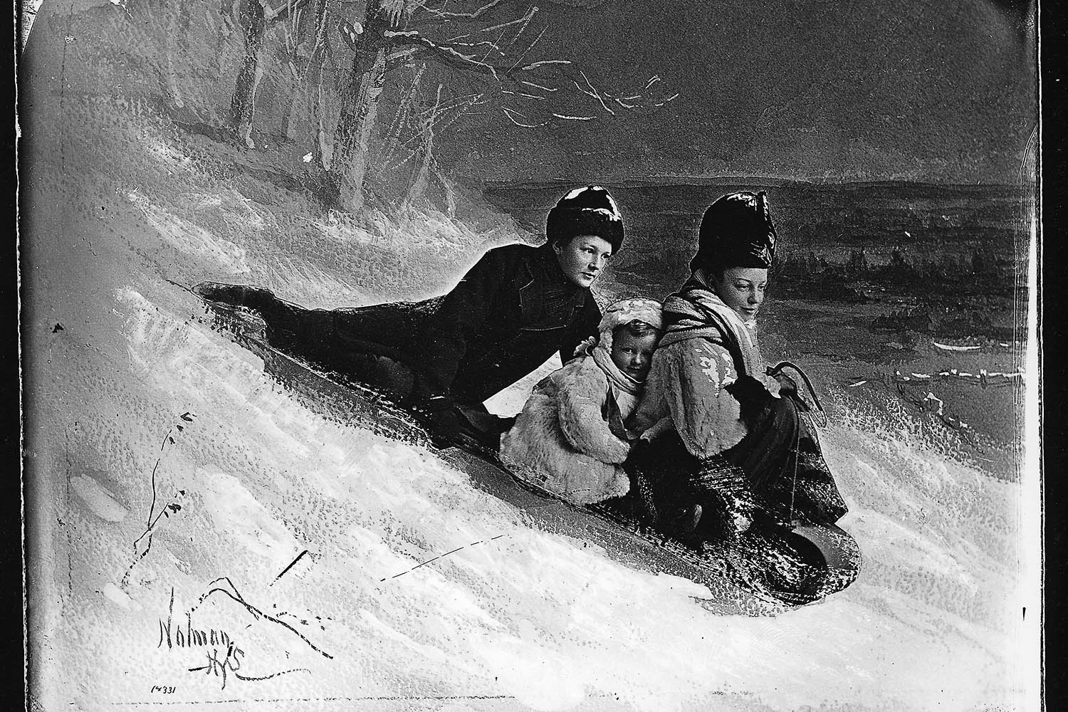 The Grindley family on a toboggan. The snow was made up of white fox fur and rock salt, and the background was painted